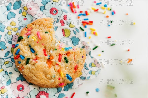 Homemade cookie with colorful sprinkle on floral napkin