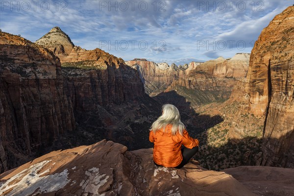 Woman sitting on cliff at Zion National Park in Utah, USA