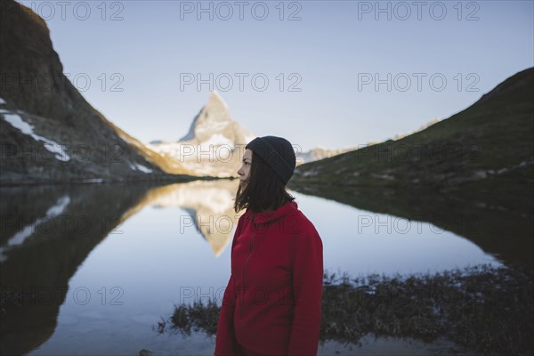 Woman standing by Matterhorn mountain and lake in Valais, Switzerland