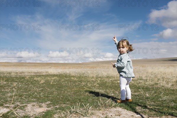 Girl (2-3) pointing towards sky