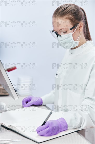 Female technician writing in notebook