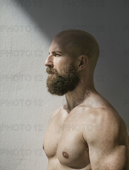 Profile of bald muscular man