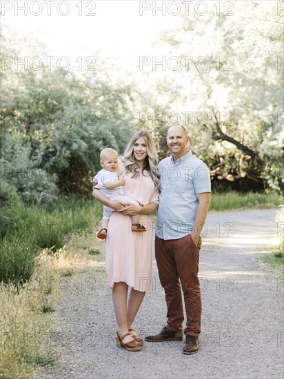 Family with baby boy (12-17 months) standing in park