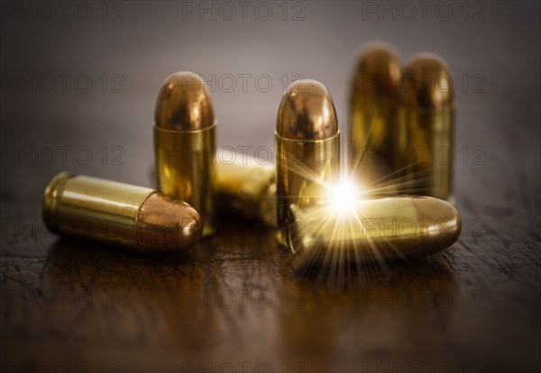 Gold bullets on wooden surface