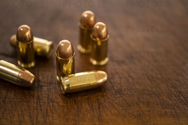 Gold bullets on wooden surface