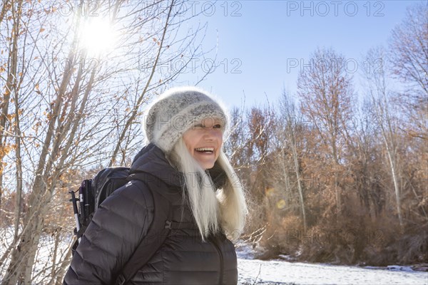 Winter portrait of smiling woman hiking along river