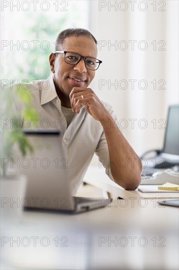 Portrait of smiling mature man working in home office