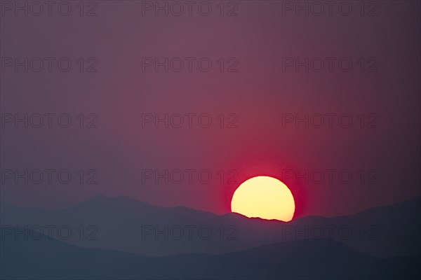 Sun setting behind hills