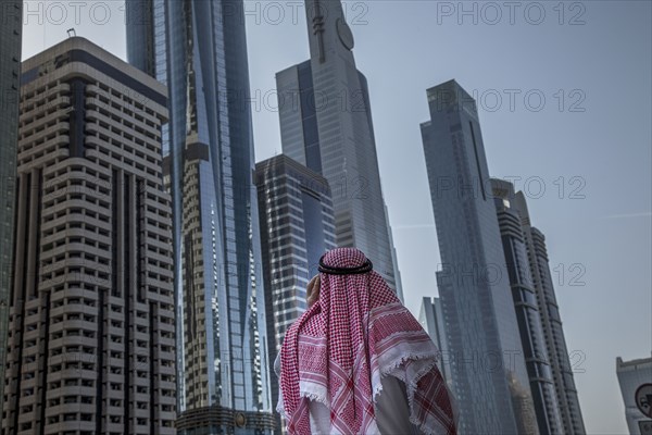 Pakistani man admiring highrise buildings in Dubai cityscape