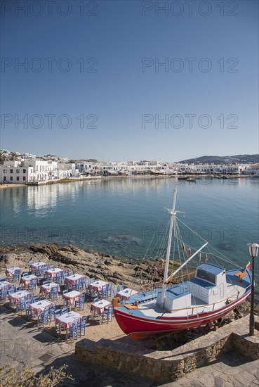 Boat and restaurant tables on oceanfront patio