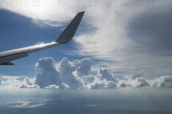 Wing of airplane flying in cloudy sky