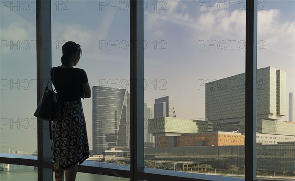 Caucasian woman admiring cityscape at window