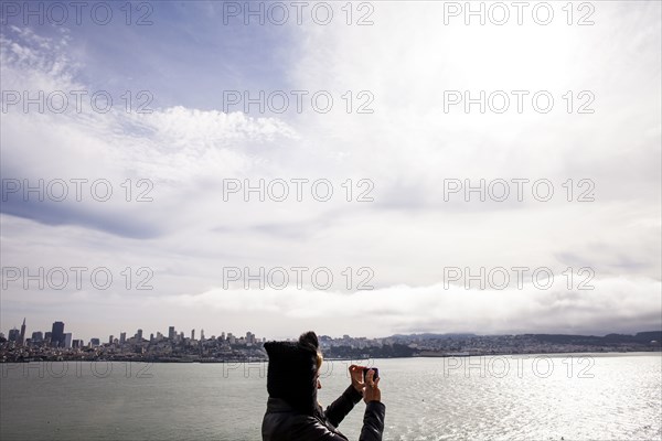 Woman taking picture of city skyline