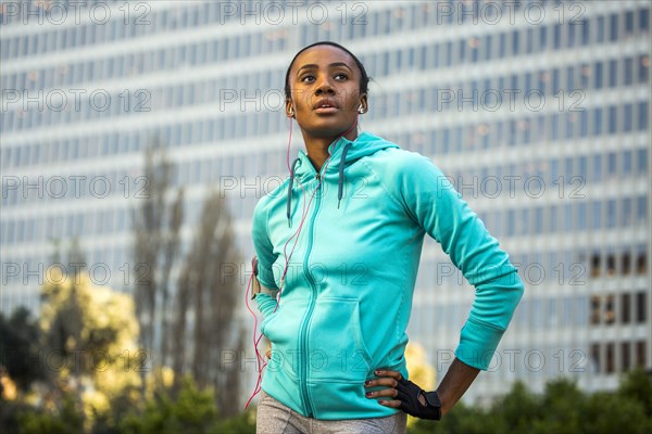 Black runner standing near high rise building