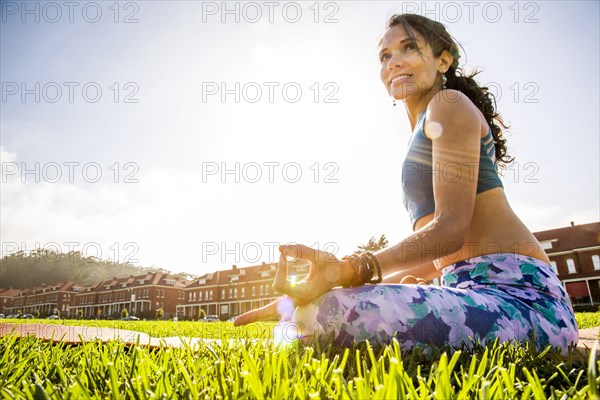 Hispanic woman practicing yoga in urban park