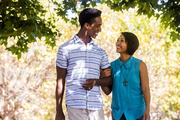 Couple walking arm-in-arm outdoors