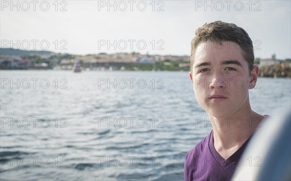 Serious Caucasian boy on boat