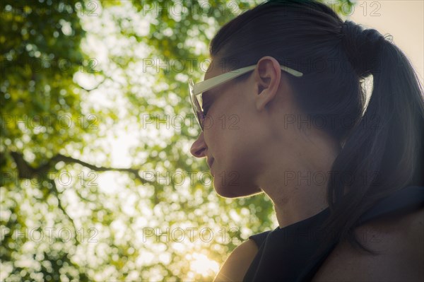 Low angle view of Caucasian woman standing under tree