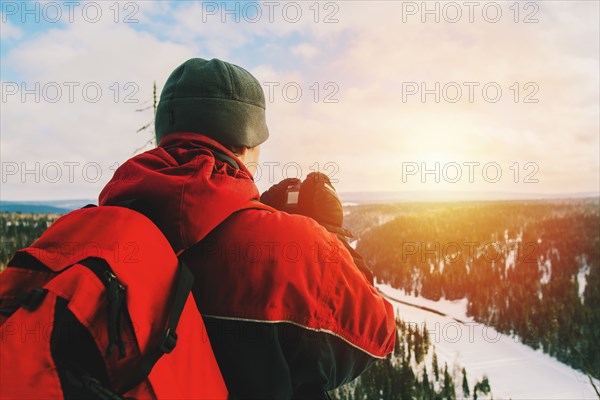 Hiker photographing remote landscape from mountain