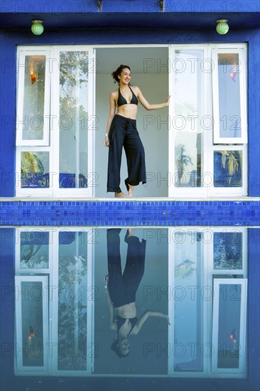 Mixed race woman reflected in swimming pool