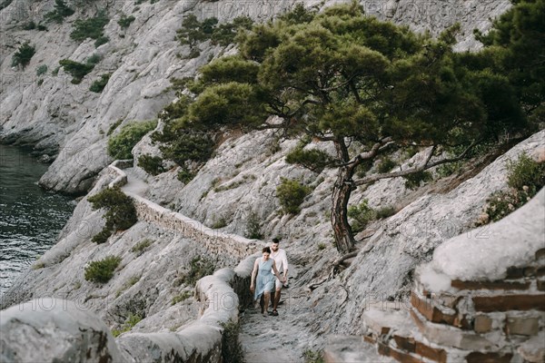 Caucasian couple hiking on cliff near lake