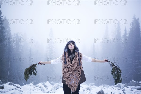 Caucasian Woman Holding Tree Branches In Snowy Woods Photo12 Tetra Images Aliyev Alexei Sergeevich