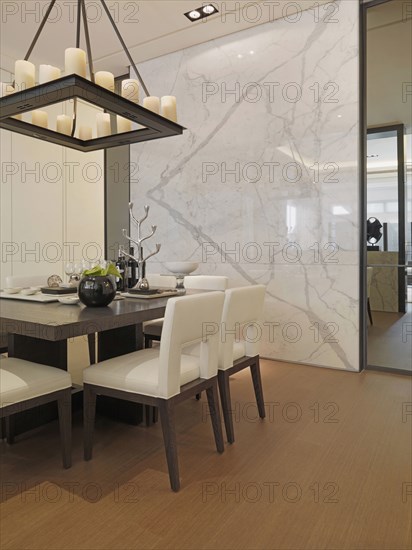 Black and white dining table in dining room with marble wall