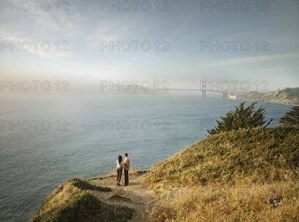 Couple admiring scenic view of bay