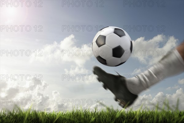 Blurred view of foot kicking soccer ball