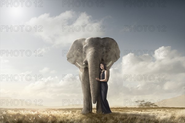 Woman hugging elephant in remote field