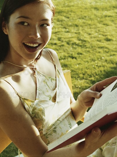 Woman reading book in chair