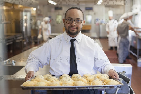 Mixed race chef with down syndrome cooking in restaurant