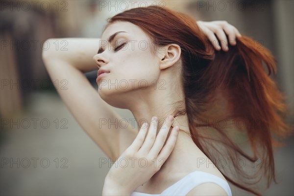 Caucasian woman holding hair and rubbing neck