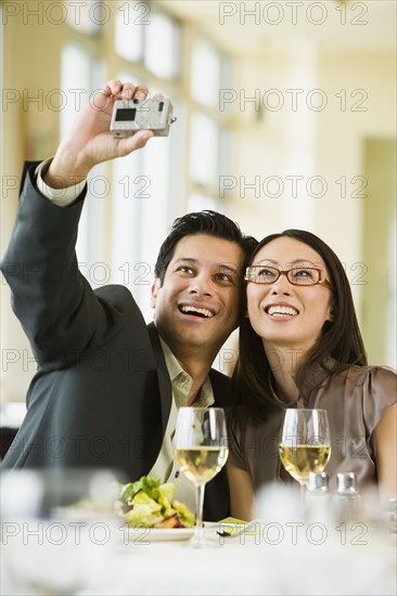 Couple taking their own photograph with digital camera