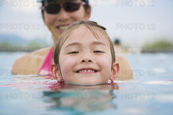 Asian girl and mother in swimming pool