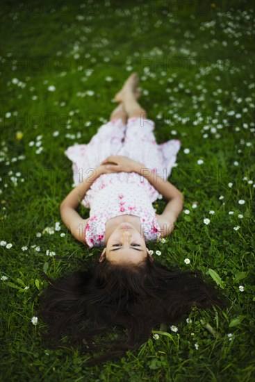 Mixed race girl laying in grass