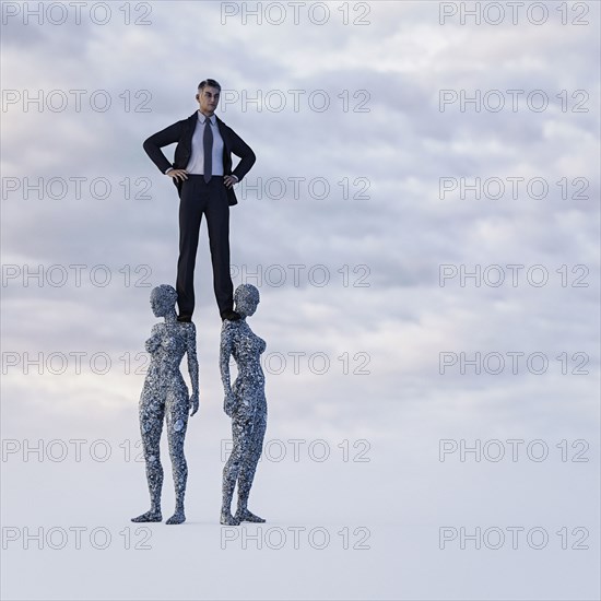 Businessman standing on shoulders of stone women