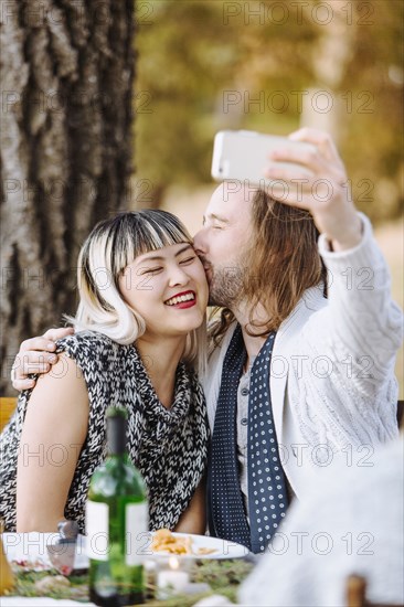 Couple taking selfie at outdoor table