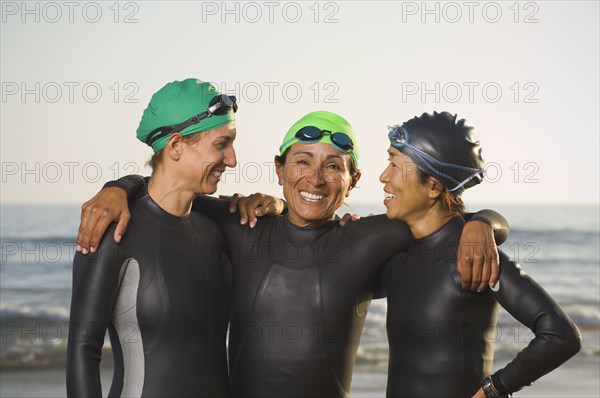 Multi-ethnic women wearing wetsuits and goggles