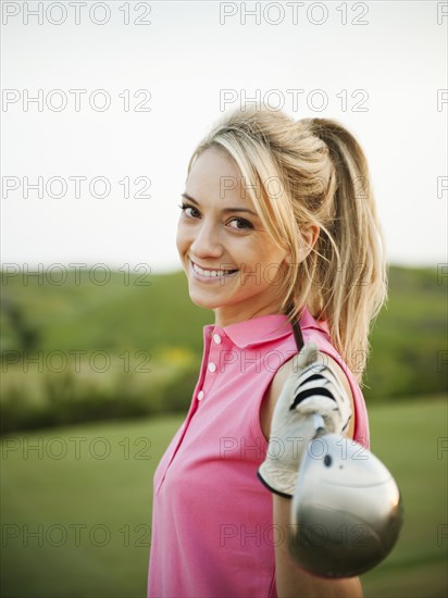 Caucasian woman holding golf club