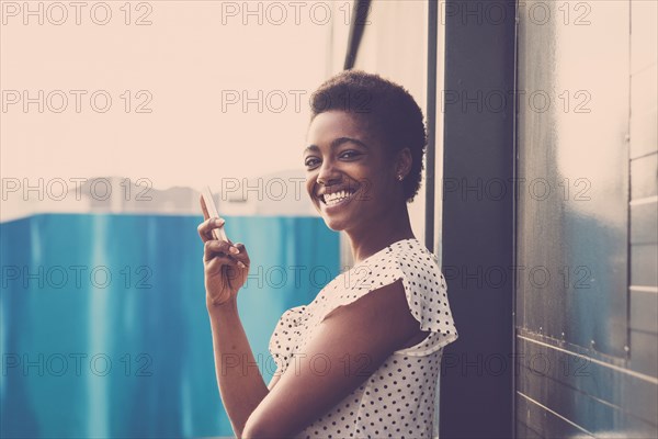 Smiling African American woman holding cell phone