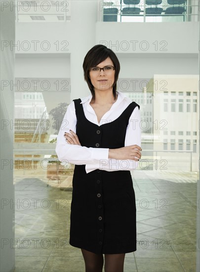 Hispanic businesswoman standing in office lobby