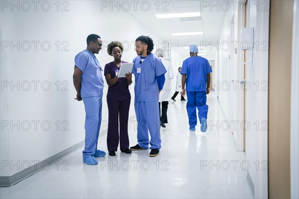Nurses discussing digital tablet in hospital