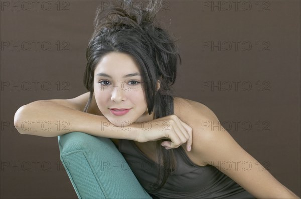 Hispanic girl resting chin on arm