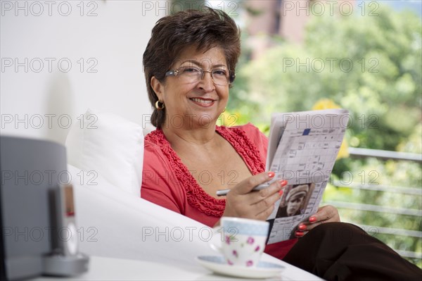 Hispanic woman reading newspaper
