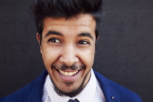 Smiling Middle Eastern man wearing jacket and tie