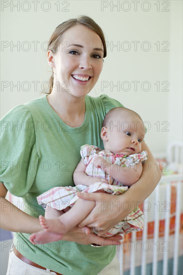 Happy Caucasian mother holding baby daughter
