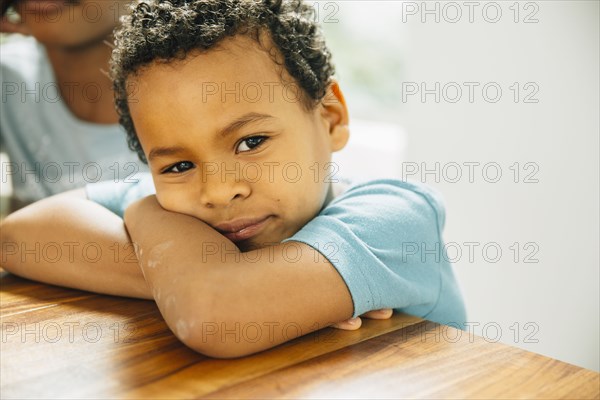 Close up of boy leaning on table
