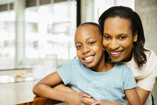 Black mother and daughter hugging