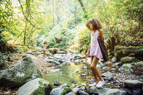 Mixed race girl exploring stream